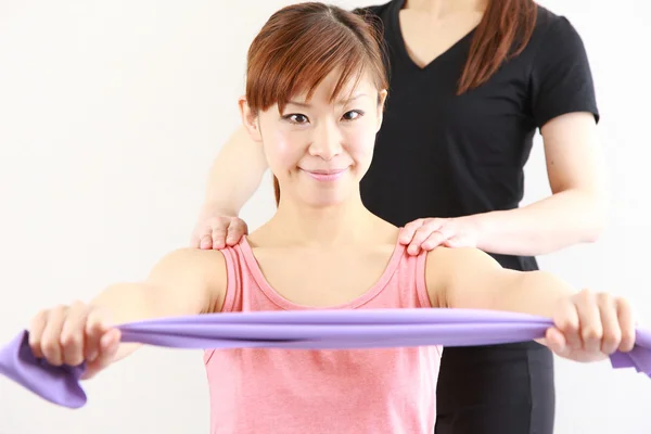 Young Japanese woman doing stretch bands exercise　 — Stock Photo, Image