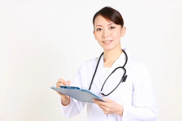 Female doctor fills in clinical record — Stock Photo, Image