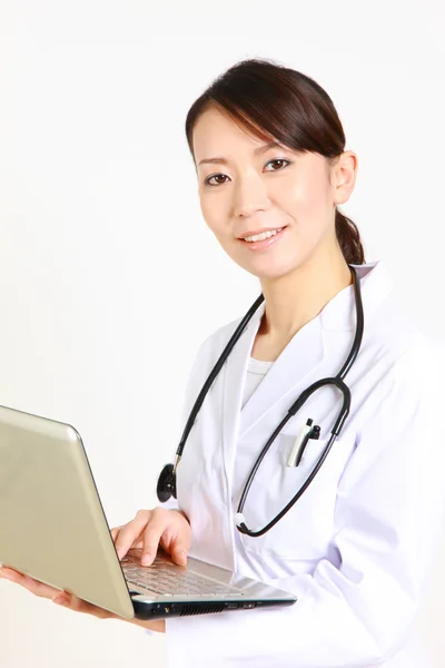 Giovane medico femminile giapponese con computer portatile sorride — Foto Stock