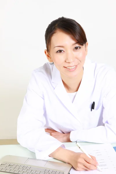 Молодая японская женщина-врач улыбается — стоковое фото