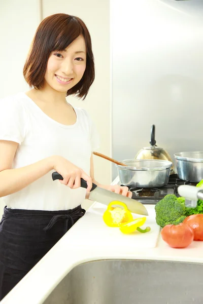 Young Japanese woman cooks in kitchen — Stock Photo, Image