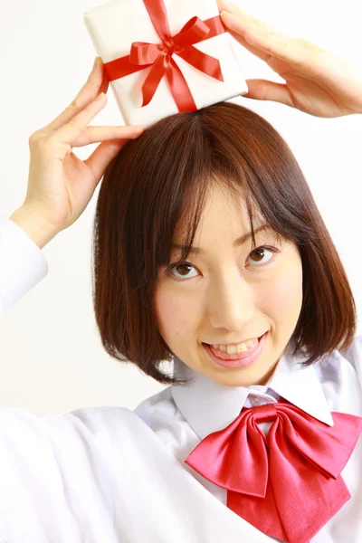 Female high school student offering a gift — Stock Photo, Image