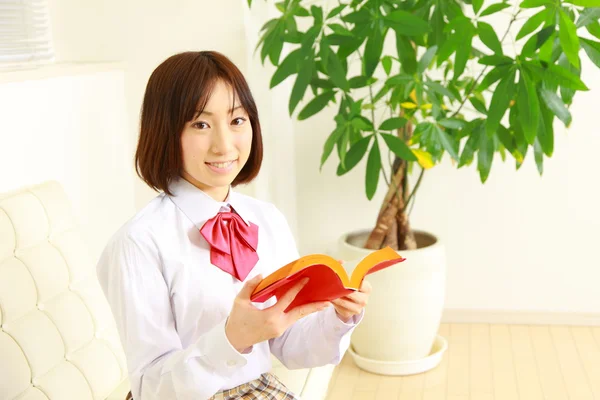 Estudante do ensino médio feminino com um livro — Fotografia de Stock
