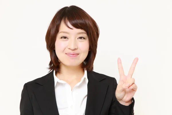 Japanse zakenvrouw tonen een teken van de overwinning — Stockfoto