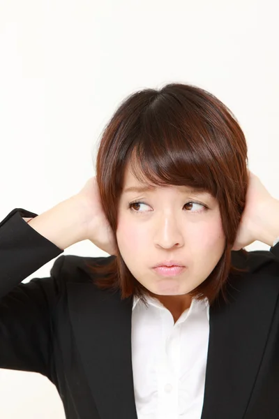 Jovem empresária japonesa sofre de barulho — Fotografia de Stock
