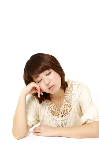 Jovem mulher japonesa dormindo na mesa — Fotografia de Stock