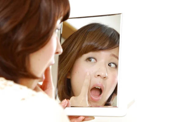 Joven mujer japonesa se preocupa por la piel seca áspera — Foto de Stock