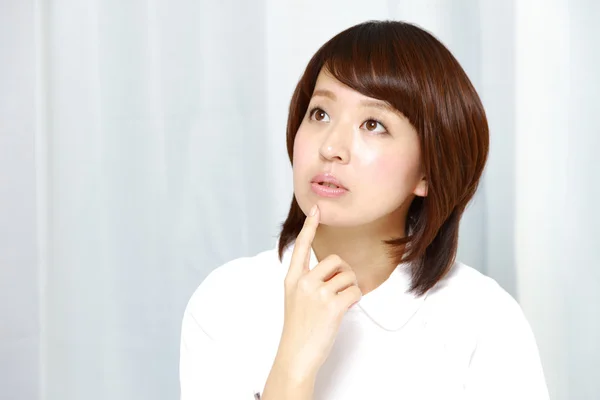 Japanese nurse thinks about something — Stock Photo, Image