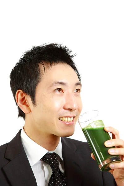 Японский бизнесмен пьет зеленый овощной сок — стоковое фото
