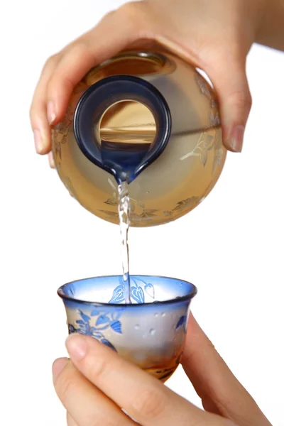 Налейте стакан японского саке. — стоковое фото