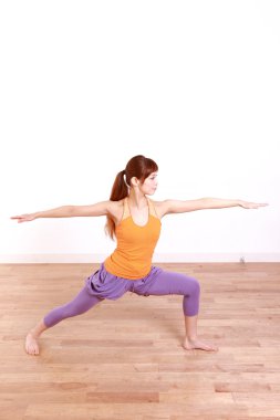Genç Japon kadın Yoga yapıyor savaşçı II poz