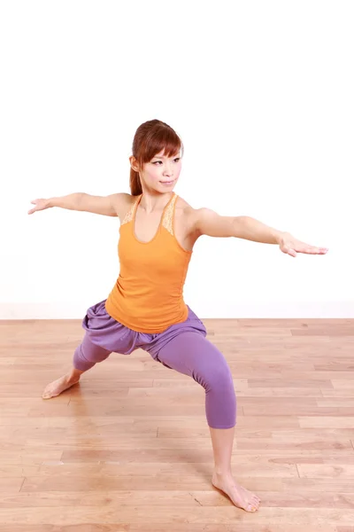 Jovem mulher japonesa fazendo YOGA guerreiro II pose — Fotografia de Stock