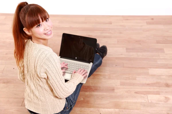 Japonês jovem mulher com computador portátil em casa — Fotografia de Stock