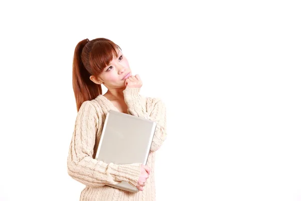 Japanse jonge vrouw met laptopcomputer denkt over iets — Stockfoto