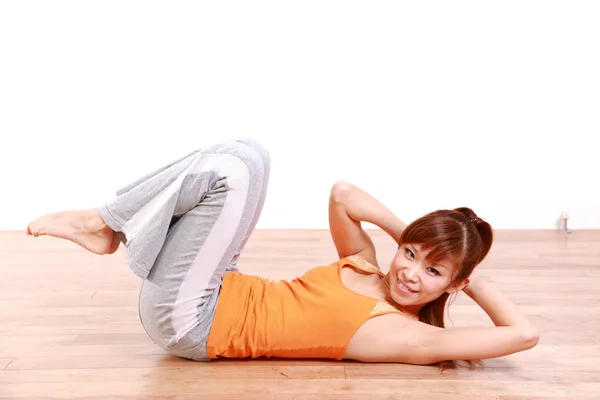 Young Japanese woman doing stomach crunches　 — Stock Photo, Image