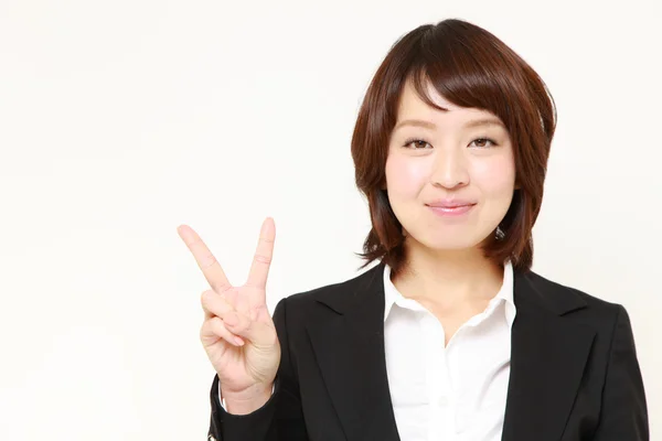 Empresária japonesa mostrando um sinal de vitória — Fotografia de Stock