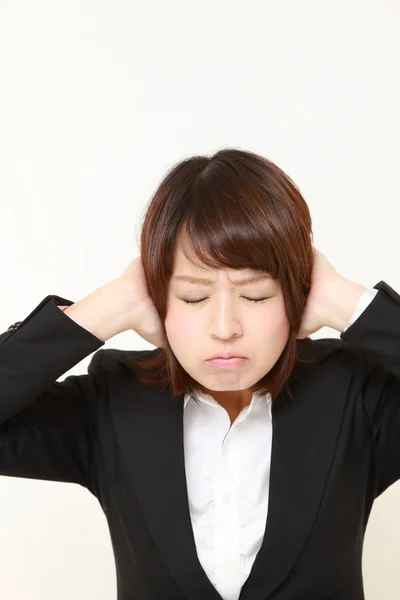 Junge japanische Geschäftsfrau leidet unter Lärm — Stockfoto