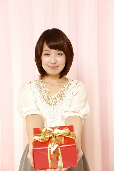 Young Japanese woman offering a gift — Stock Photo, Image