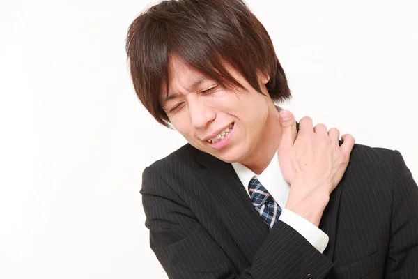 Joven empresario japonés sufre de dolor de cuello — Foto de Stock