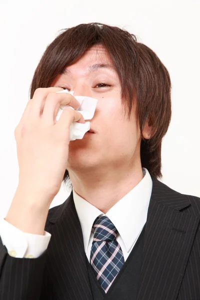 Hombre de negocios con una alergia estornudando en el tejido —  Fotos de Stock
