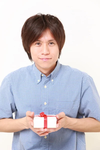 Jovem japonês oferecendo um presente — Fotografia de Stock