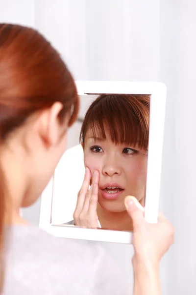 Joven mujer japonesa se preocupa por la piel seca áspera — Foto de Stock