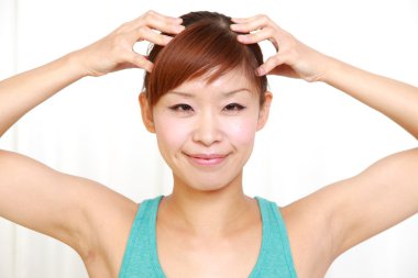 Genç kadının kendini baş masajı yapması