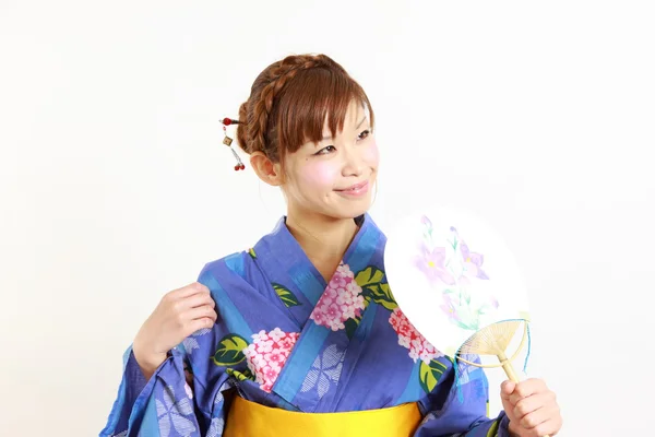 Junge Frau trägt japanischen Kimono mit Papierfächer — Stockfoto