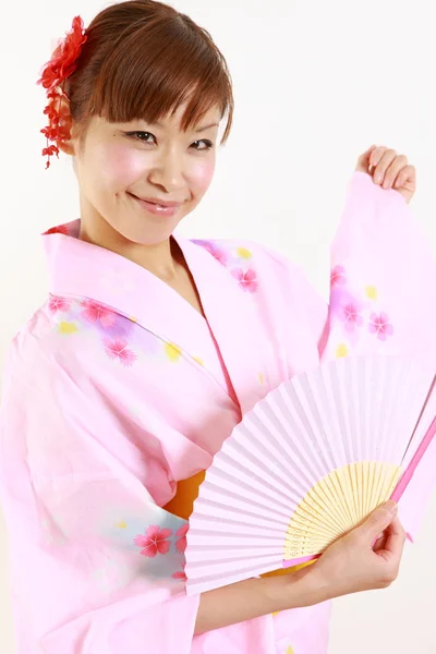 Mladá žena nosí japonské kimono s papírem ventilátor — Stock fotografie