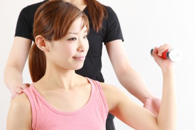 Genç Japon kadın dumbbell egzersiz yaparak