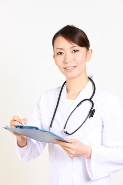 Kadın doktor klinik kaydında doldurur