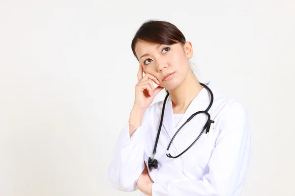 O doutor fêmea japonês pensa sobre algo　 — Fotografia de Stock