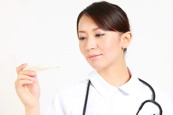 Young Japanese nurse with clinical thermometer　 — ストック写真