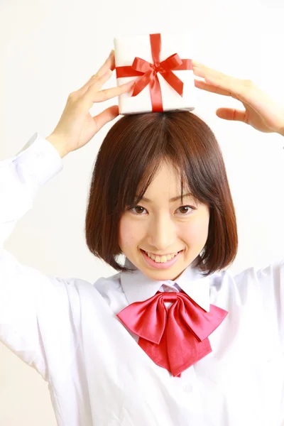 Female high school student offering a gift — Stock Photo, Image