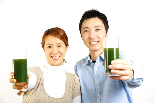 Japansk par med gröna grönsaksjuice — Stockfoto