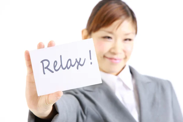 Businesswoman showing a card with word  RELAX — Stock Photo, Image