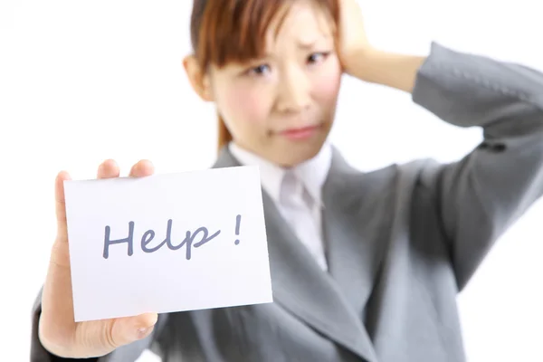 Perplexed businesswoman showing a card with word  HELP — Stock Photo, Image