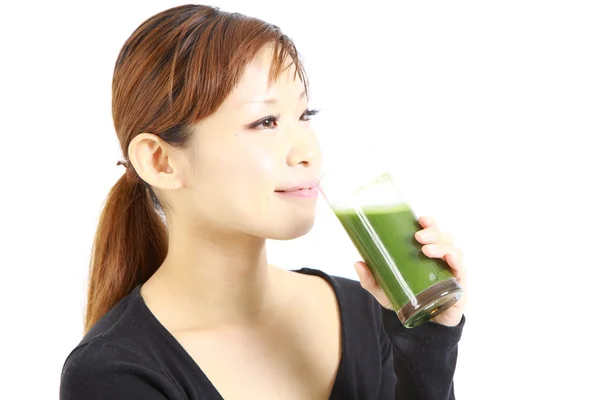 Jeune femme japonaise avec du jus de légumes verts — Photo