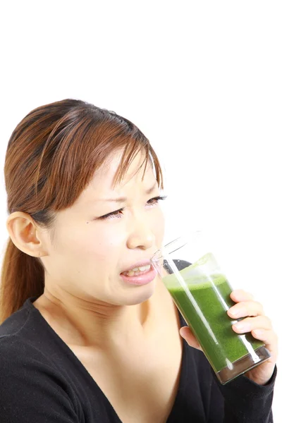 Young Japanese woman with green vegetable juice — Stock Photo, Image