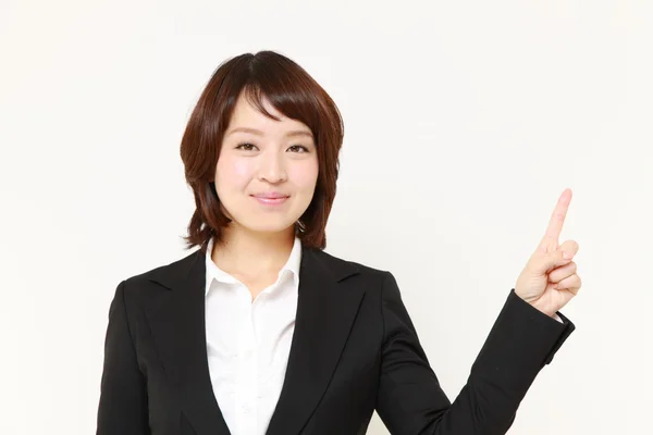 Japonesa empresaria presentando y mostrando algo — Foto de Stock
