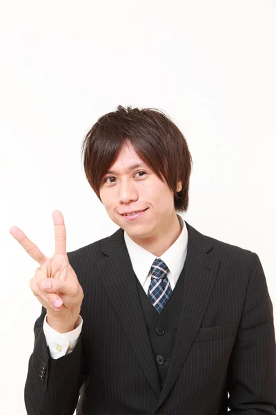 Junger japanischer Geschäftsmann zeigt ein Siegeszeichen — Stockfoto