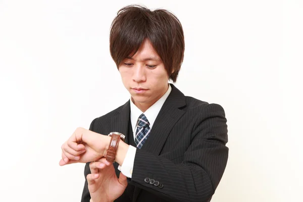 Geschäftsmann kontrolliert die Uhrzeit auf seiner Uhr — Stockfoto
