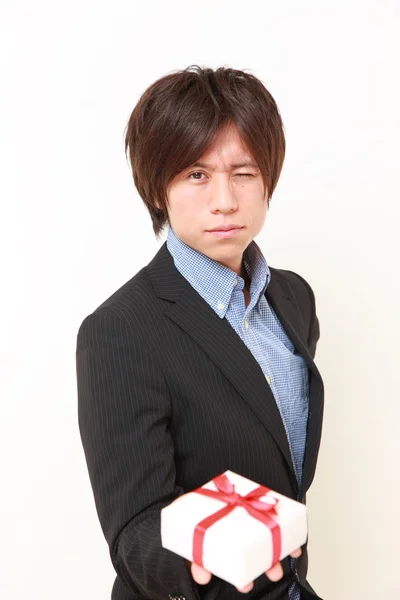 Молодой японский мужчина предлагает подарок — стоковое фото