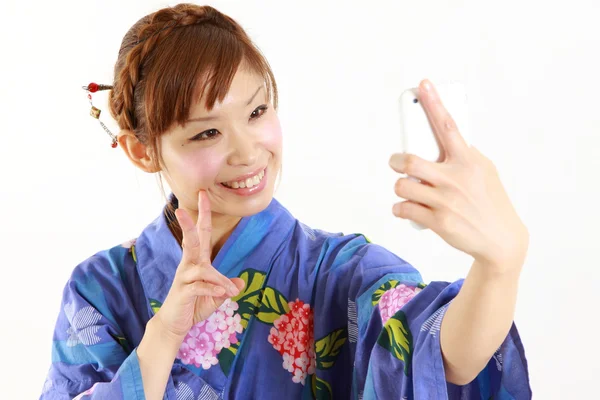 Japonesa mujer usando kimono toma un selfie —  Fotos de Stock