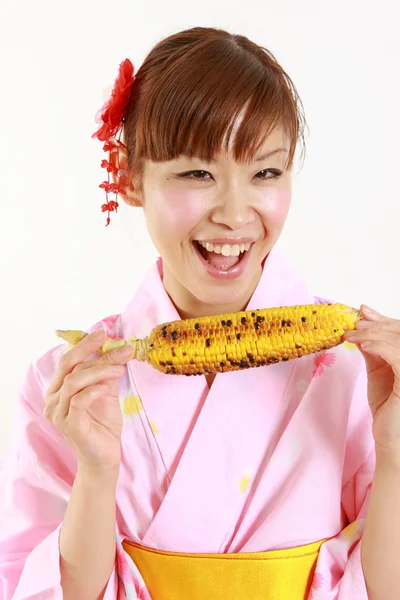 Japanerin mit gegrilltem Mais — Stockfoto