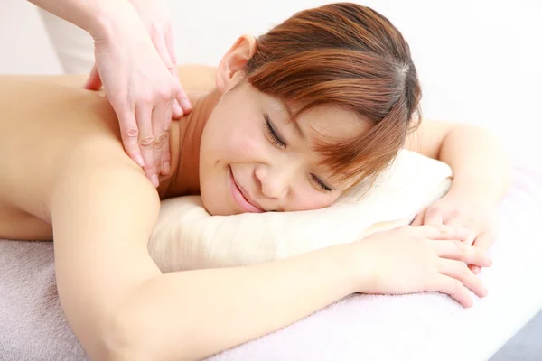 Jovem mulher japonesa recebendo uma massagem no ombro — Fotografia de Stock