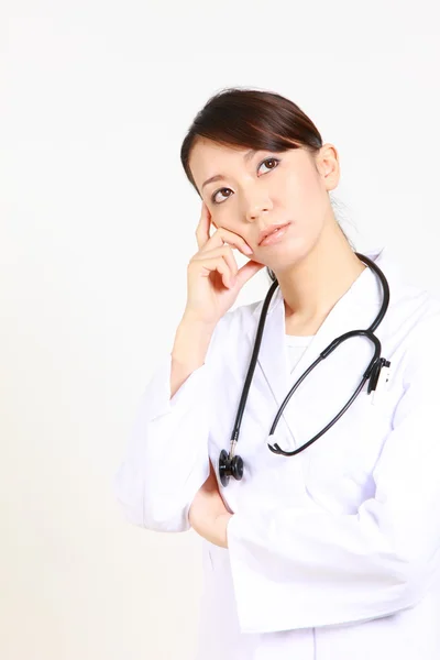 Japonais femme médecin pense à quelque chose — Photo