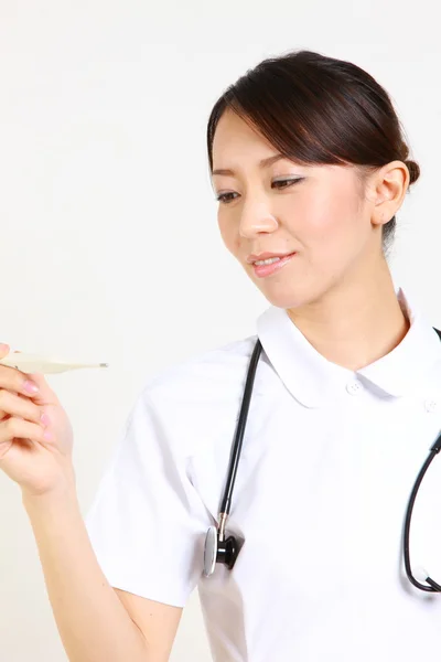 Young Japanese nurse with clinical thermometer　 — Stock Photo, Image