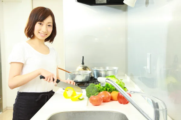 Young Japanese woman cooks in kitchen — Stock Photo, Image