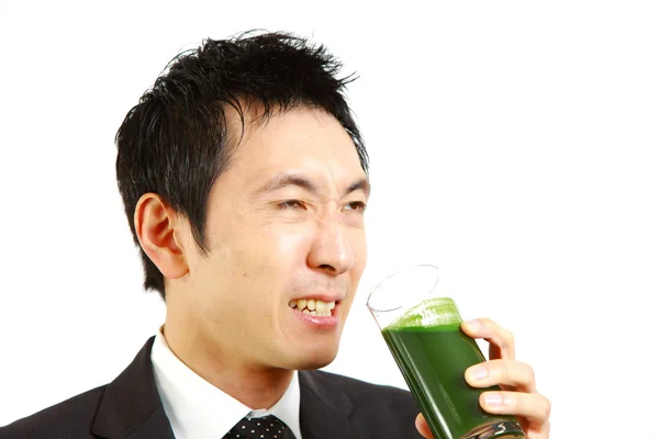 Empresário japonês bebe suco de legumes verde — Fotografia de Stock